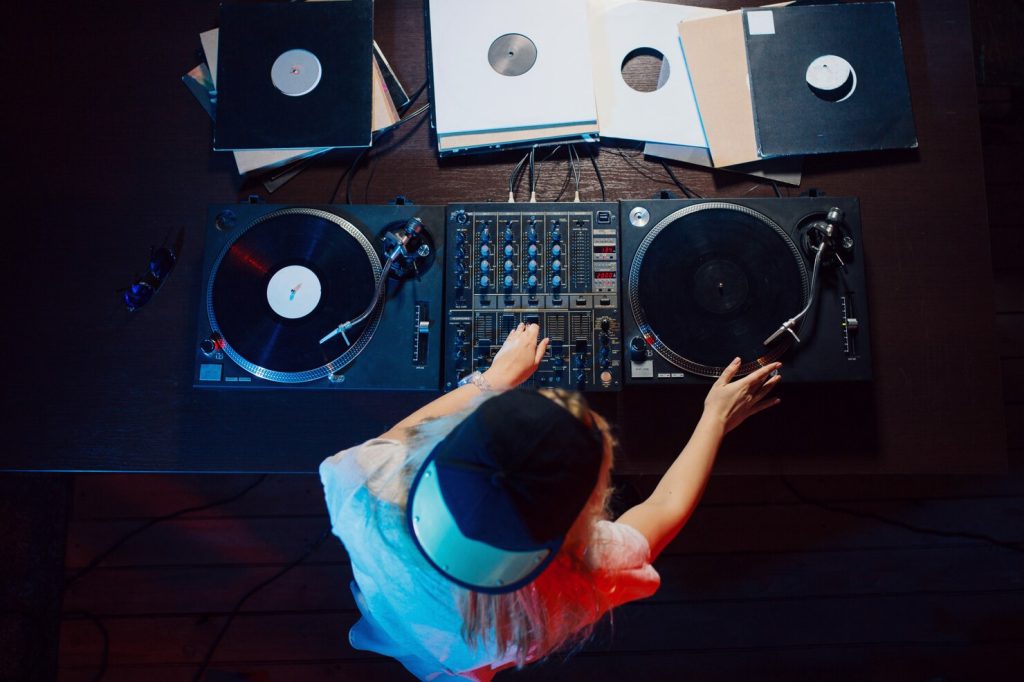 Image illustrant un DJ talentueux en train de mixer de la musique aux platines lors d'une soirée animée