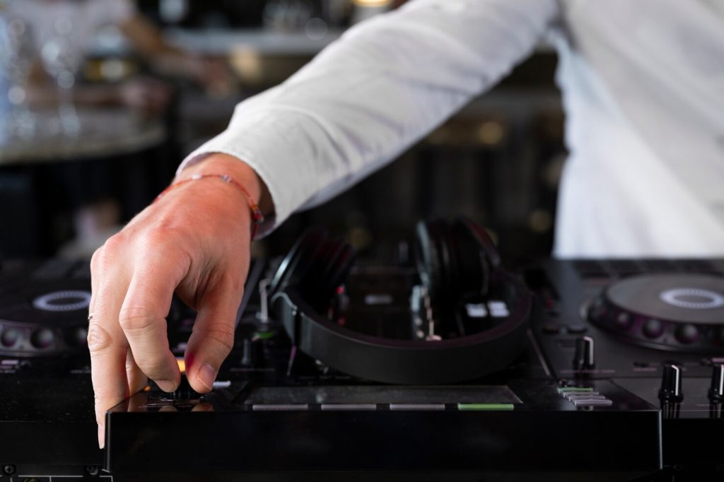 Image illustrant un DJ professionnel en train de mixer de la musique lors d'une soirée animée